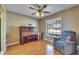 Charming living room boasts hardwood flooring, a piano, and a relaxing recliner by a bright window at 15820 Sapwood St, Tampa, FL 33624