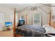 Cozy bedroom featuring a unique wooden four-poster bed, neutral walls, and a designated workspace at 1605 Prescott S St, St Petersburg, FL 33712
