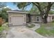 Single-story home with stucco exterior, attached garage, and mature landscaping at 1605 Prescott S St, St Petersburg, FL 33712