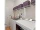 Bright laundry room with modern washer and dryer, plus storage shelves at 1605 Prescott S St, St Petersburg, FL 33712