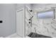 Modern bathroom featuring a white marble tiled shower with black fixtures and a small window at 1716 Bermuda Ct, Safety Harbor, FL 34695