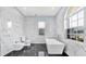 Elegant bathroom featuring black and white tile floors, marble walls, and a large stand alone tub at 1716 Bermuda Ct, Safety Harbor, FL 34695