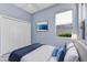 Bright bedroom with white closet doors, blue accent pillows and an ocean-themed picture above the bed at 1716 Bermuda Ct, Safety Harbor, FL 34695