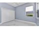 Bright bedroom with white closet doors, a window, and a marble floor at 1716 Bermuda Ct, Safety Harbor, FL 34695