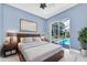 Staged bedroom featuring a wooden bed frame, a ceiling fan, and sliding doors that lead to a pool at 1716 Bermuda Ct, Safety Harbor, FL 34695