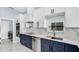 Bright kitchen with stainless steel appliances, white cabinets, blue accent cabinetry, and quartz countertops at 1716 Bermuda Ct, Safety Harbor, FL 34695
