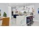 Stylish kitchen features white cabinetry, stainless steel appliances, blue accents, and quartz countertops with breakfast bar at 1716 Bermuda Ct, Safety Harbor, FL 34695