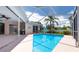 A screened-in pool is surrounded by a deck and overlooks the backyard at 1716 Bermuda Ct, Safety Harbor, FL 34695