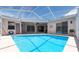 A screened-in pool is surrounded by a deck and overlooks the backyard at 1716 Bermuda Ct, Safety Harbor, FL 34695