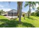 Backyard pool featuring a screened enclosure and tropical landscaping, perfect for enjoying the outdoors at 1716 Bermuda Ct, Safety Harbor, FL 34695