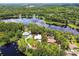 Aerial view of property and home, outlined in red, situated on a lake with lush green trees surrounding it at 17906 Loretta Ln, Lutz, FL 33548