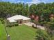 Aerial view of the home showcasing a sprawling lawn, lush landscaping, and a long driveway at 17906 Loretta Ln, Lutz, FL 33548