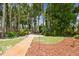 Backyard stone path with mature trees and landscaping at 17906 Loretta Ln, Lutz, FL 33548