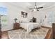 Comfortable bedroom featuring a ceiling fan, an area rug, and shutters on the windows at 17906 Loretta Ln, Lutz, FL 33548