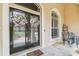 Charming front entrance with decorative wreaths on double doors and stone flooring at 17906 Loretta Ln, Lutz, FL 33548