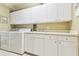 Functional laundry room with built-in cabinets, sink, washer and dryer hookups at 17906 Loretta Ln, Lutz, FL 33548