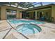 Inviting screened-in pool and hot tub area with stone surround, perfect for outdoor relaxation and entertaining at 17906 Loretta Ln, Lutz, FL 33548