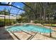 Screened in-ground pool and hot tub with stone surround and mature trees, creating a serene outdoor space at 17906 Loretta Ln, Lutz, FL 33548