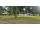 Open backyard featuring an enclosed back porch and several storage buildings, plus mature trees at 1908 S Kingsway Rd, Seffner, FL 33584