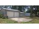 Spacious two-car garage with metal doors and a concrete pad, plus smaller sheds at 1908 S Kingsway Rd, Seffner, FL 33584