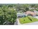 Aerial view of a charming home with a spacious, fenced backyard, complemented by a well-manicured front lawn at 2025 Jefferson Ave, Dunedin, FL 34698