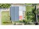 Aerial shot of roof and backyard, featuring well-maintained lawn, privacy fence, and a mature shade tree at 2025 Jefferson Ave, Dunedin, FL 34698