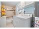 Bathroom with laundry area featuring a tub-shower combo and updated appliances at 2025 Jefferson Ave, Dunedin, FL 34698