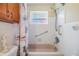 Clean bathroom with shower and bathtub featuring white tile and nautical-themed shower curtain at 2025 Jefferson Ave, Dunedin, FL 34698