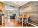 Cozy dining area featuring wood-look accent wall, wood floors and table, open to adjacent living area at 2025 Jefferson Ave, Dunedin, FL 34698