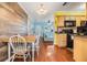 Open concept dining area featuring wood paneling and views to the kitchen and living room at 2025 Jefferson Ave, Dunedin, FL 34698