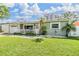 Welcoming home exterior with neat landscaping, a decorative flamingo, and a cozy front porch area with seating at 2025 Jefferson Ave, Dunedin, FL 34698