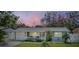 Inviting single-story home boasting a well-maintained lawn, crisp white trim, attached garage and classic white picket fence at 2025 Jefferson Ave, Dunedin, FL 34698
