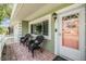 Inviting front porch with brick flooring, comfortable seating, and a stylish front door entrance at 2025 Jefferson Ave, Dunedin, FL 34698