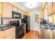 Well-equipped kitchen featuring wood cabinets, granite counters, colorful backsplash, and appliances at 2025 Jefferson Ave, Dunedin, FL 34698