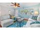Bright living room featuring light blue walls, cozy seating, and a large window with natural light at 2025 Jefferson Ave, Dunedin, FL 34698