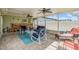 Screened-in patio with brick flooring, multiple seating areas, and ceiling fans at 2025 Jefferson Ave, Dunedin, FL 34698