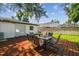 Outdoor dining set on the wooden deck, surrounded by lush grass and a secure privacy fence at 206 N Beverly Ave # 1/2, Tampa, FL 33609