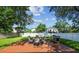 Backyard with an outdoor dining set, wooded deck, grill, and lush green grass at 206 N Beverly Ave # 1/2, Tampa, FL 33609