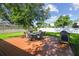 View of the backyard with wooden deck, an outdoor dining set and lush green grass at 206 N Beverly Ave # 1/2, Tampa, FL 33609