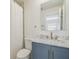 Bathroom featuring a blue vanity, marble countertop, and decorative mirror at 206 N Beverly Ave # 1/2, Tampa, FL 33609