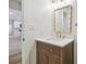 Bathroom featuring a decorative mirror, wood vanity, and a glimpse to the kitchen at 206 N Beverly Ave # 1/2, Tampa, FL 33609