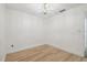 Bright bedroom featuring light wood flooring, paneled walls, and a modern chandelier at 206 N Beverly Ave # 1/2, Tampa, FL 33609