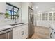 Kitchen featuring stainless steel appliances, white cabinets, window, and tile backsplash at 206 N Beverly Ave # 1/2, Tampa, FL 33609