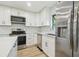 Modern kitchen with stainless steel appliances, white cabinetry and subway tile backsplash at 206 N Beverly Ave # 1/2, Tampa, FL 33609