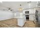 Spacious kitchen with island, open to living space, wood-look tile floors and modern appliances at 206 N Beverly Ave # 1/2, Tampa, FL 33609