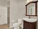 Well-lit bathroom featuring a glass door shower, toilet, and vanity with a wooden framed mirror at 20835 Lake Talia Blvd, Land O Lakes, FL 34638