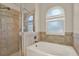 Bathroom with a separate shower and soaking tub combination featuring decorative tile walls and a frosted window at 20835 Lake Talia Blvd, Land O Lakes, FL 34638