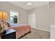 Bright bedroom offering a window, carpet floors, double-door closet and a comfortable bed with side table at 20835 Lake Talia Blvd, Land O Lakes, FL 34638