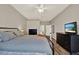 Well-lit bedroom with ceiling fan, wood floors, light-colored walls, gingham bedspread and two dressers at 20835 Lake Talia Blvd, Land O Lakes, FL 34638