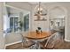 Bright dining area with wood table, white chairs, decorative lighting, and view of the patio at 20835 Lake Talia Blvd, Land O Lakes, FL 34638
